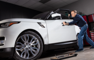 Technician performing dent repair at auto body shop in Duluth, MN